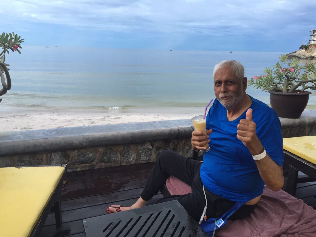 Father at the beach, giving a thumbs up